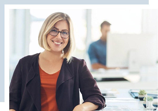 a woman student at a computer lab smiling to the camera