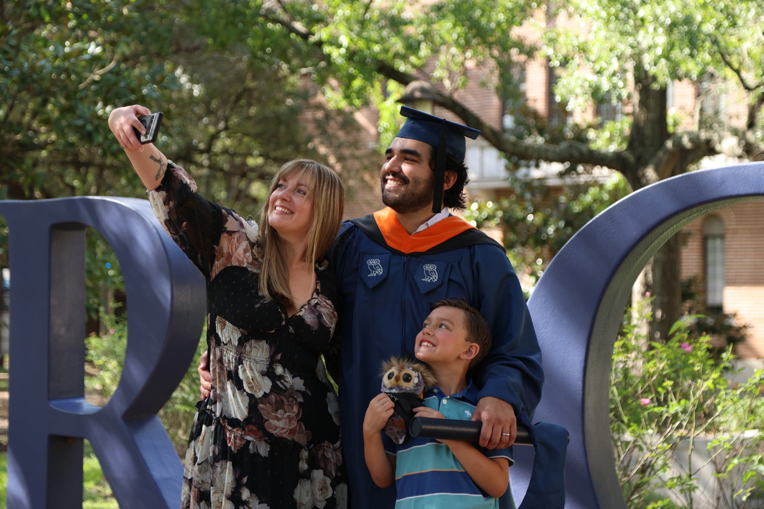 A family selfie featuring a man, a woman, and their son, all smiling and enjoying a fun moment together.