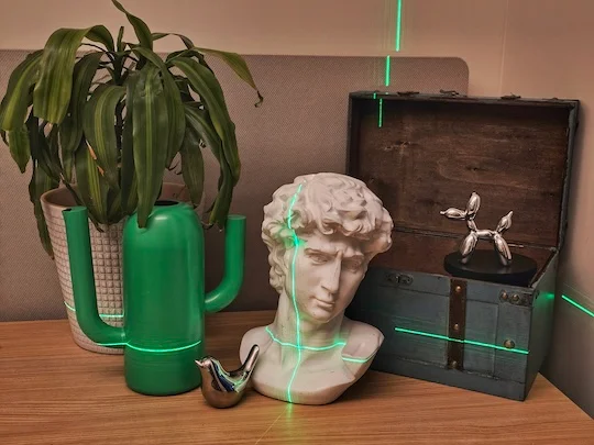 A laser scanner captures a scene containing objects with varying reflectance, from matte to highly reflective, is scanned with a green laser. Computational analysis separates the different surface types, allowing the system to measure less reflective objects directly and reconstruct the shape of highly reflective objects from the reflected light. (Photo courtesy of Aniket Dashpute/Rice University)