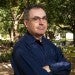 Dan Wallach standing outside by trees on Rice University campus